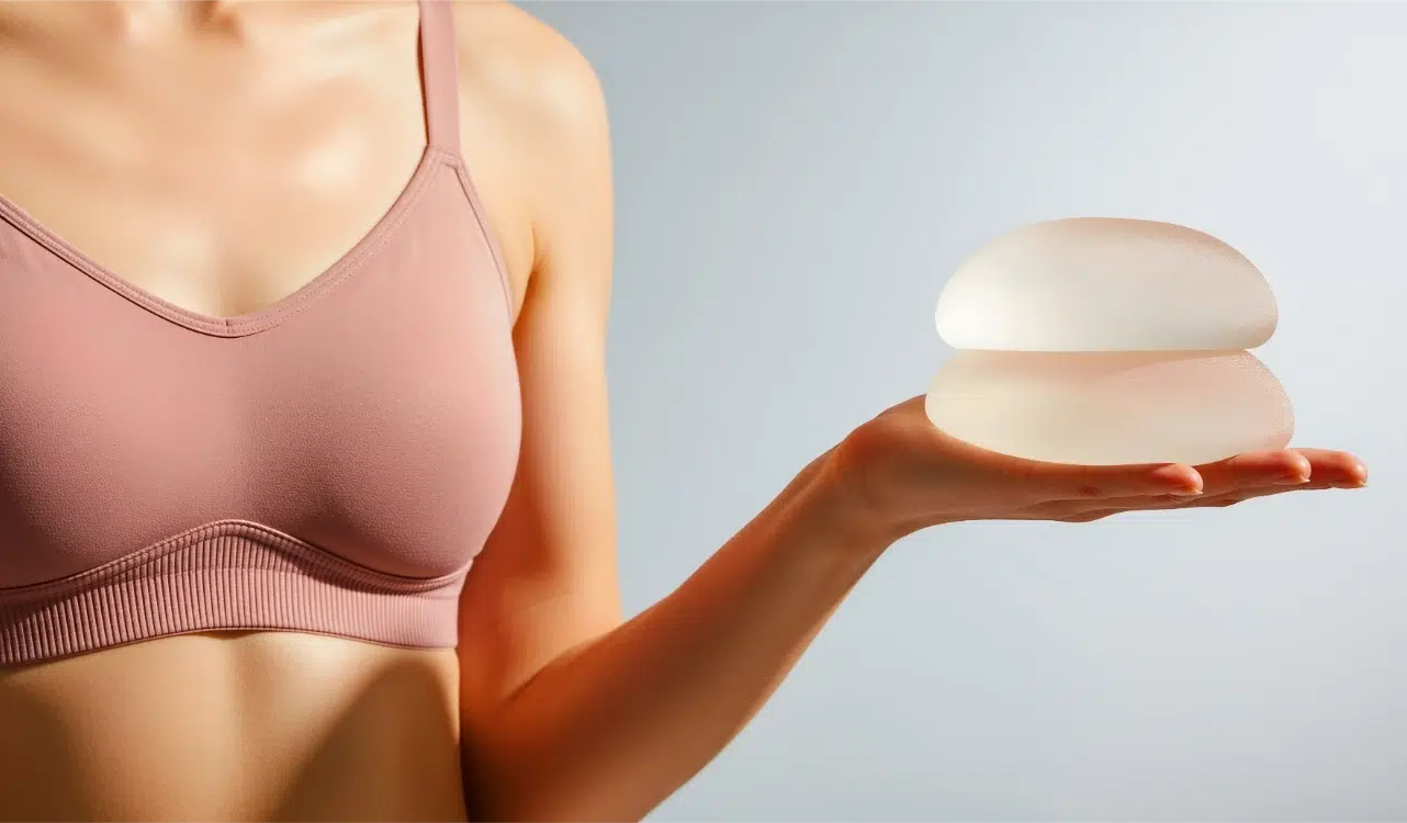 woman holding silicone breast implants in her hand